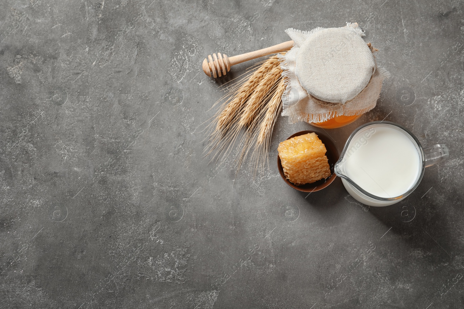 Photo of Beautiful composition with milk and honey on grey background