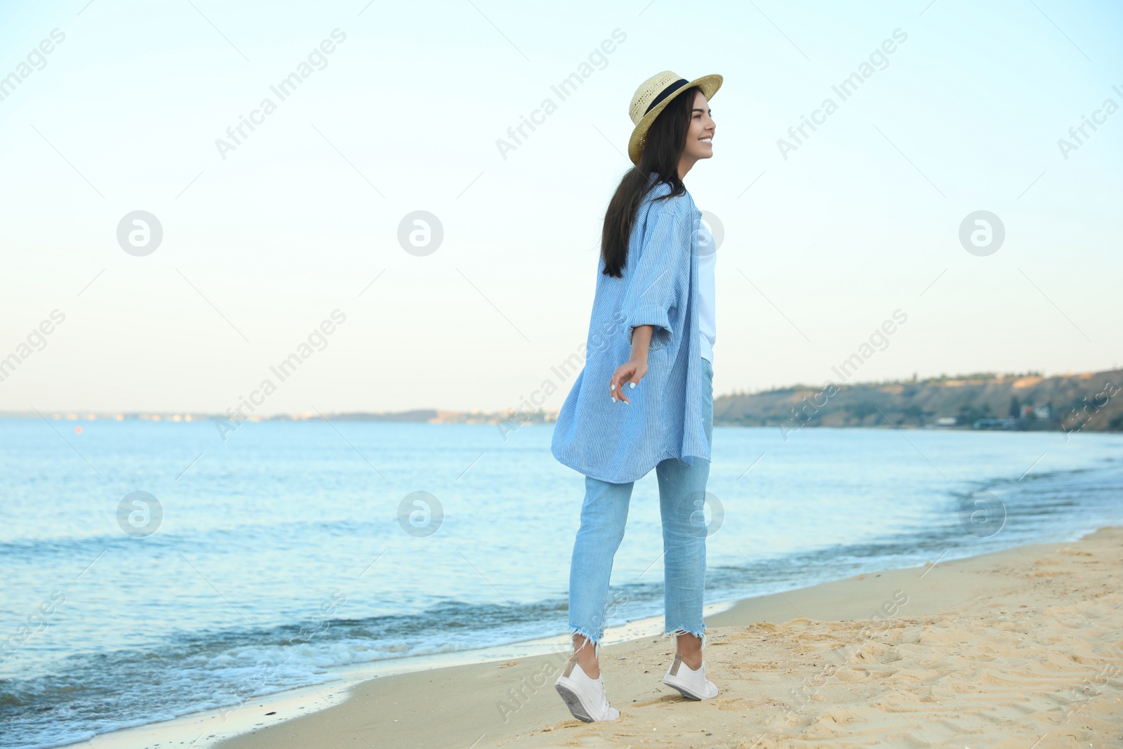 Photo of Beautiful young woman in casual outfit on beach