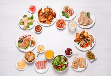 Photo of Buffet service. Frame of different dishes on white wooden table, space for text