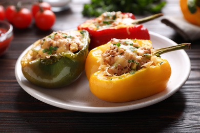 Photo of Tasty stuffed bell peppers on wooden table, closeup