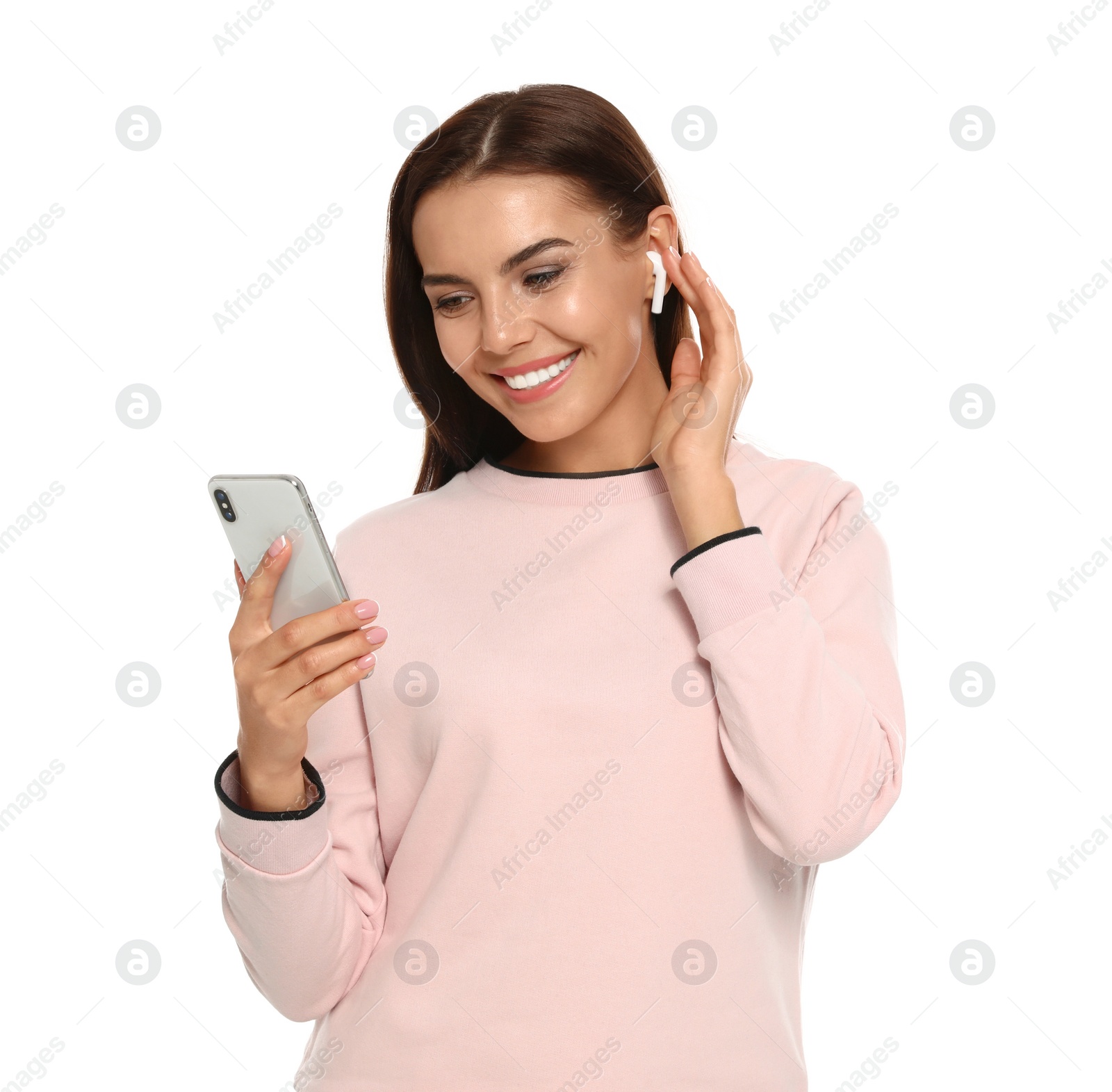 Photo of Happy young woman with smartphone listening to music through wireless earphones on white background