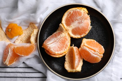 Photo of Fresh ripe tangerines on striped cloth, flat lay