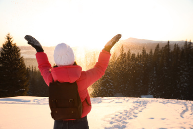 Photo of Young woman having fun outdoors on snowy winter day