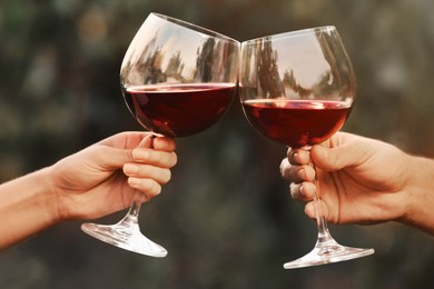 Image of Couple with glasses of red wine outdoors, closeup
