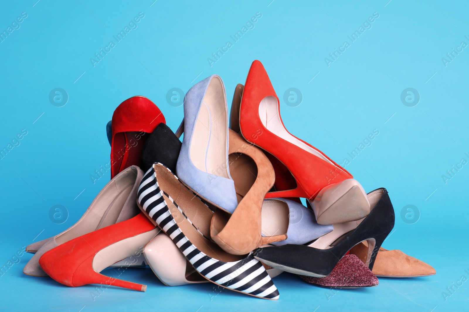 Photo of Heap of different shoes on color background