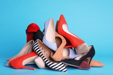 Photo of Heap of different shoes on color background