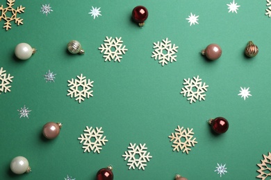 Photo of Frame made of Christmas decorations on green background, top view with space for text. Winter season