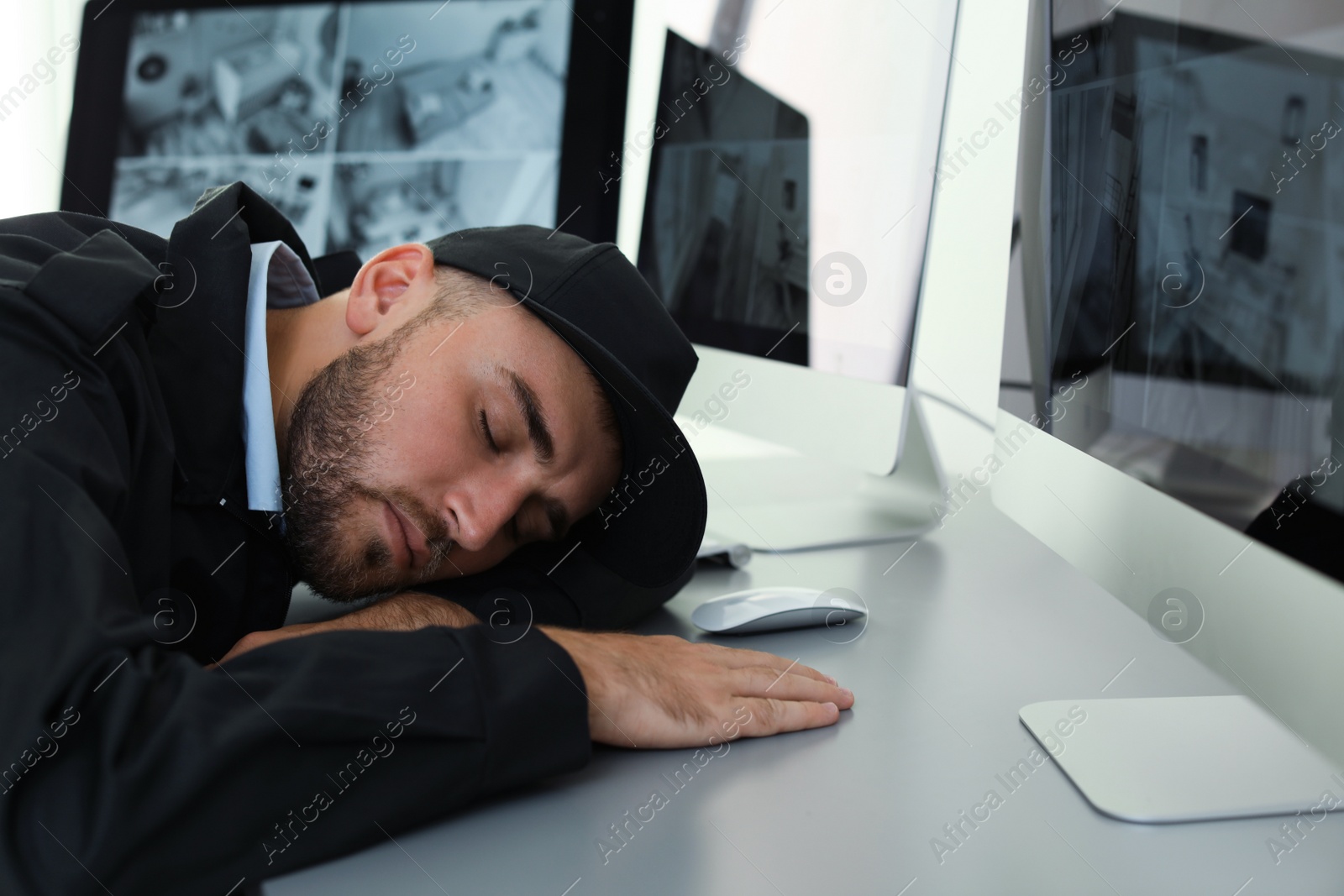 Photo of Male security guard sleeping at workplace indoors