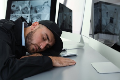 Photo of Male security guard sleeping at workplace indoors