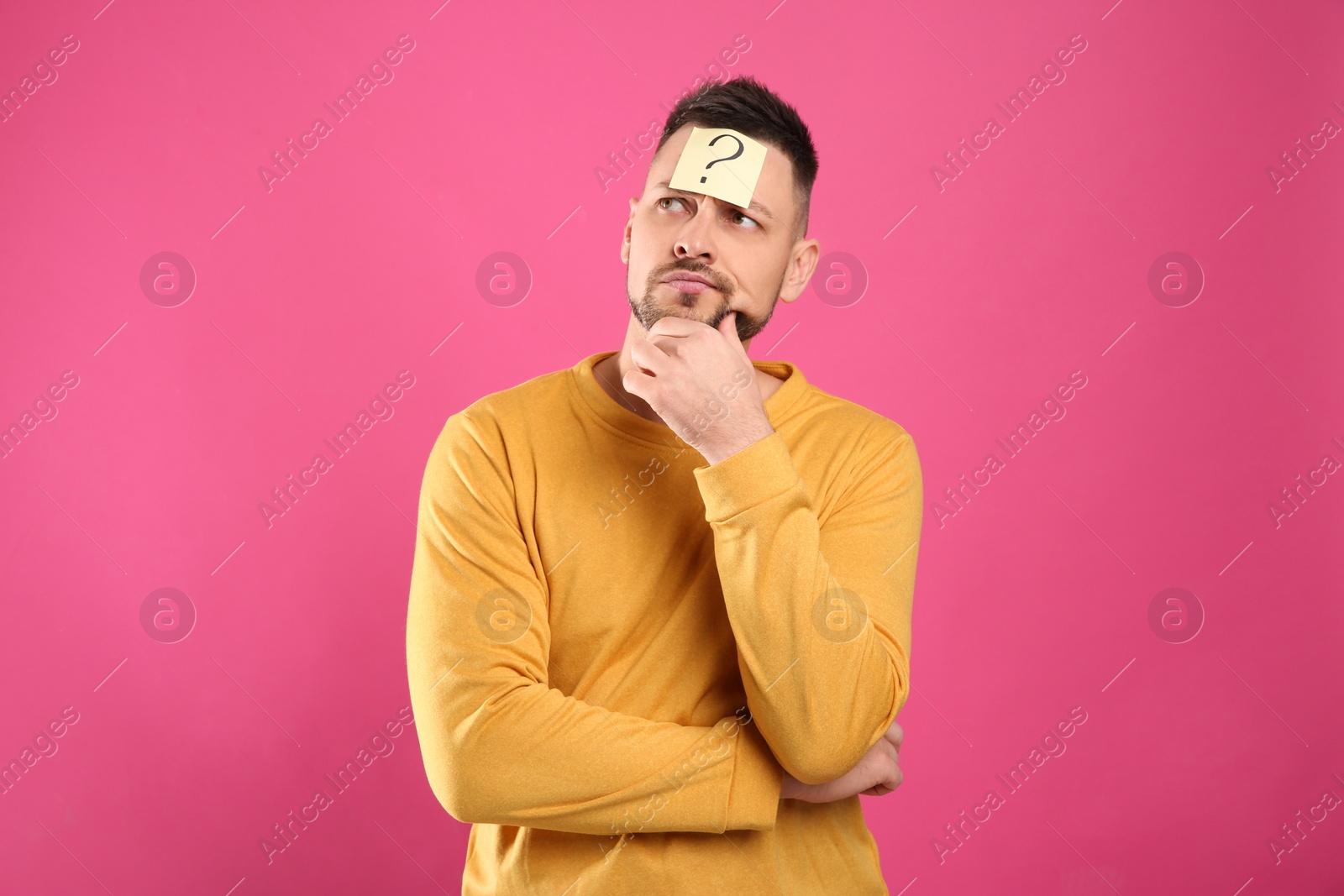 Photo of Emotional man with question mark on pink background