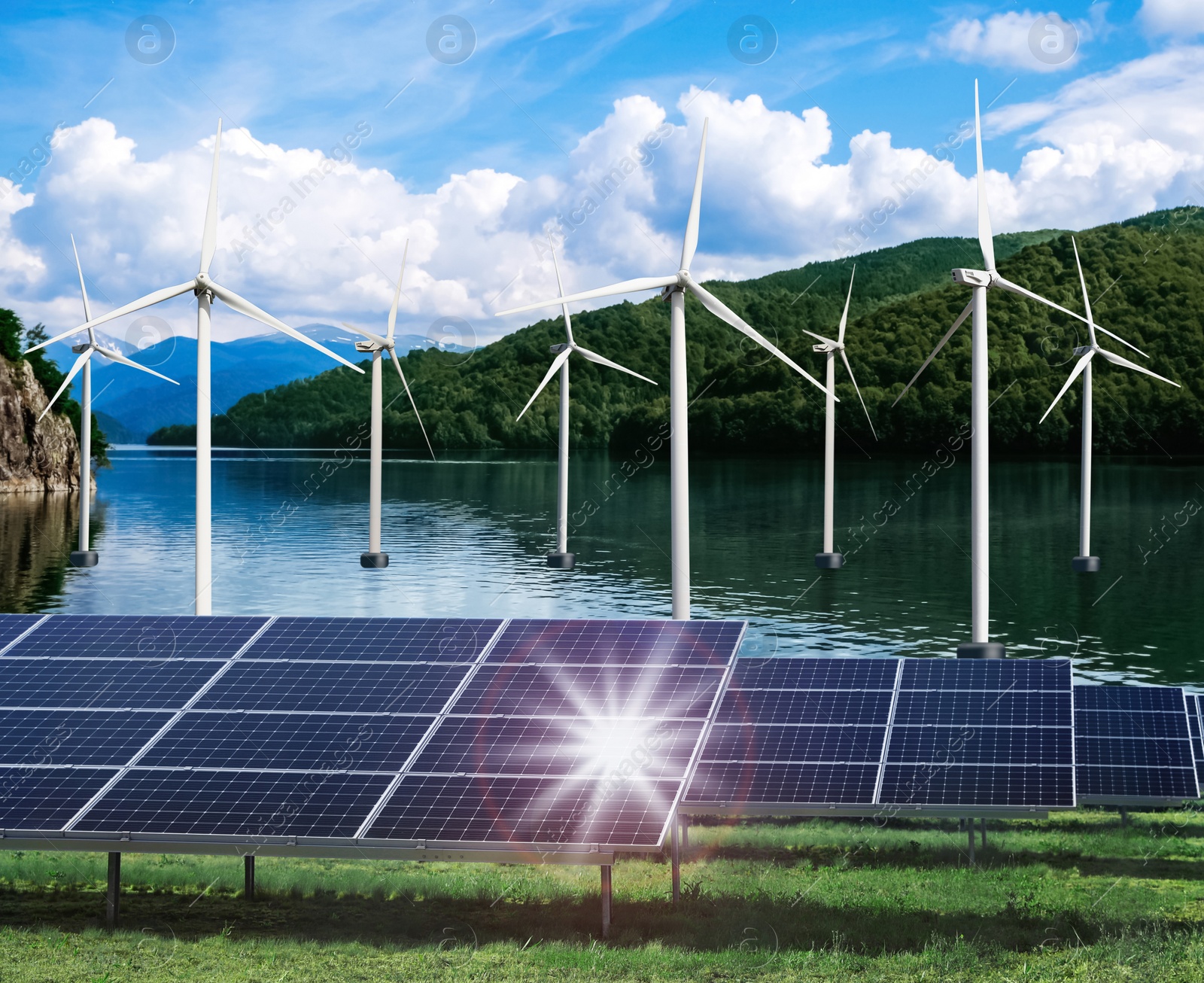 Image of Alternative energy sources. Wind turbines installed in water near bank with solar panels