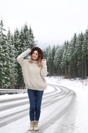 Photo of Young woman walking near snowy forest. Winter vacation