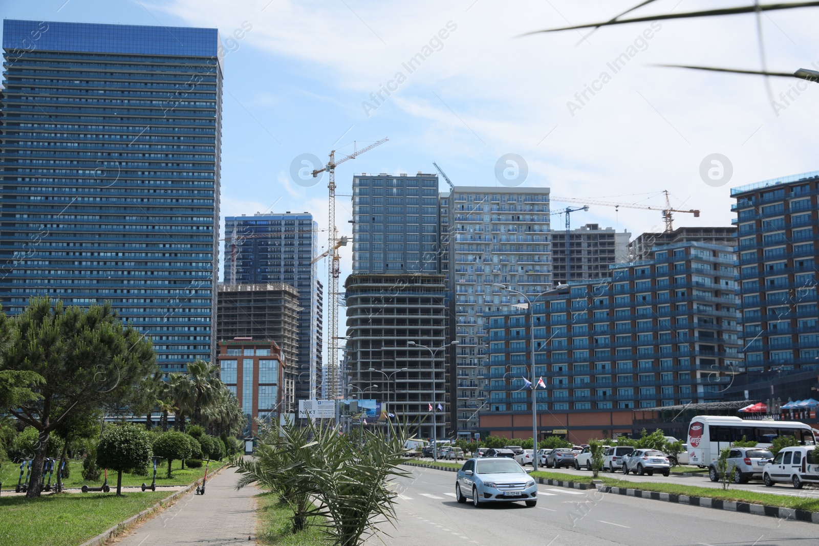 Photo of Batumi, Georgia - June 06, 2022: View of construction site with tower cranes near unfinished and modern buildings outdoors