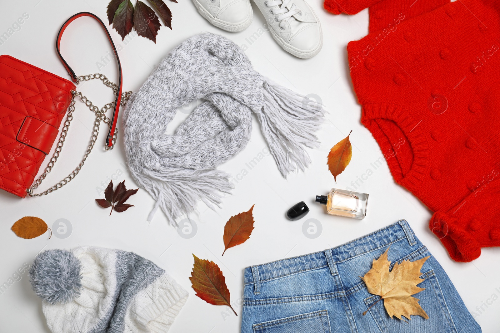 Photo of Stylish outfit and autumn leaves on white background, top view. Trendy warm clothes