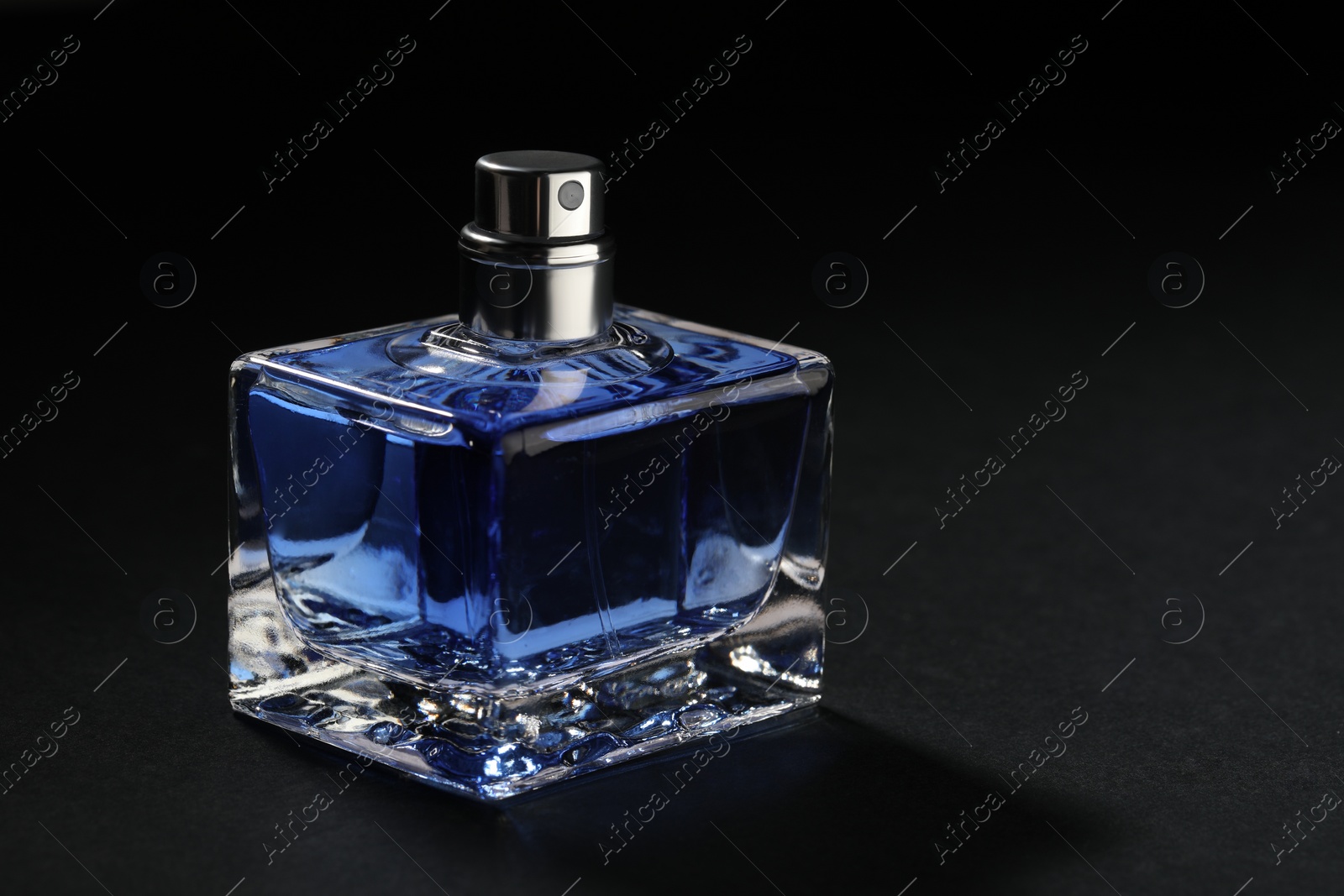 Photo of Blue men's perfume in bottle on black background, space for text