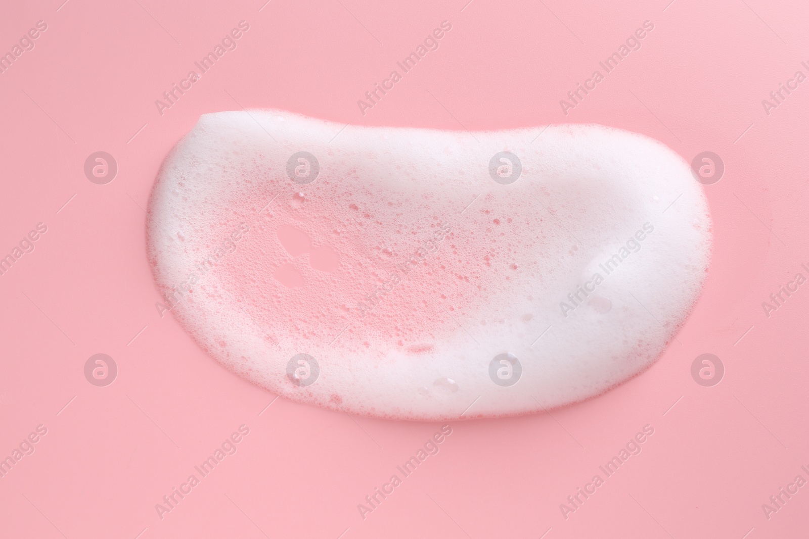 Photo of Sample of fluffy foam on pink background, top view