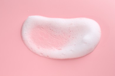 Sample of fluffy foam on pink background, top view