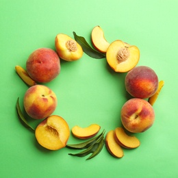 Flat lay composition with fresh peaches on green background. Space for text