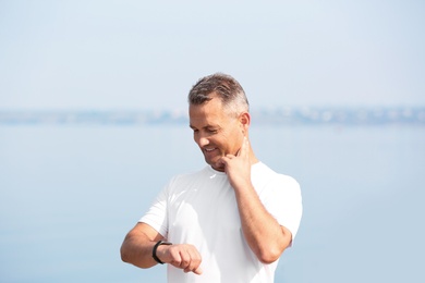 Man checking pulse outdoors on sunny day