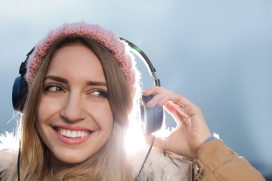 Photo of Young woman with headphones listening to music outdoors