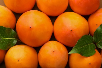 Photo of Delicious ripe juicy persimmons as background, top view