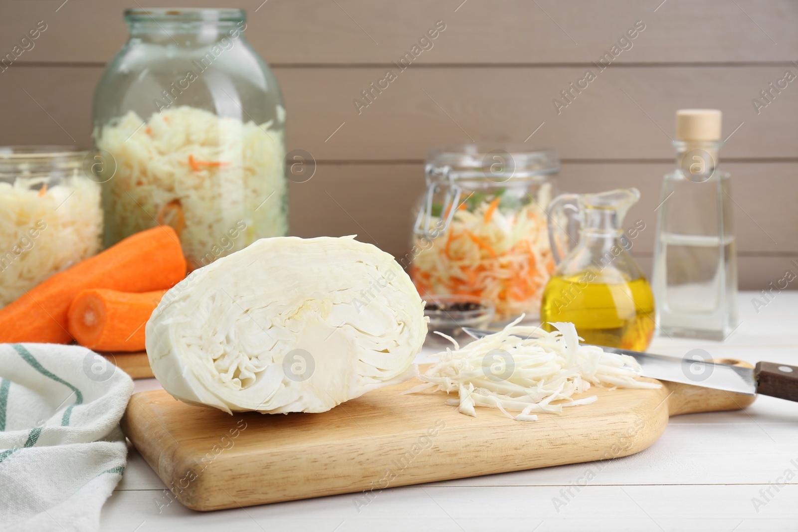 Photo of Cooking delicious sauerkraut soup. Fresh chopped cabbage and ingredients on white wooden table