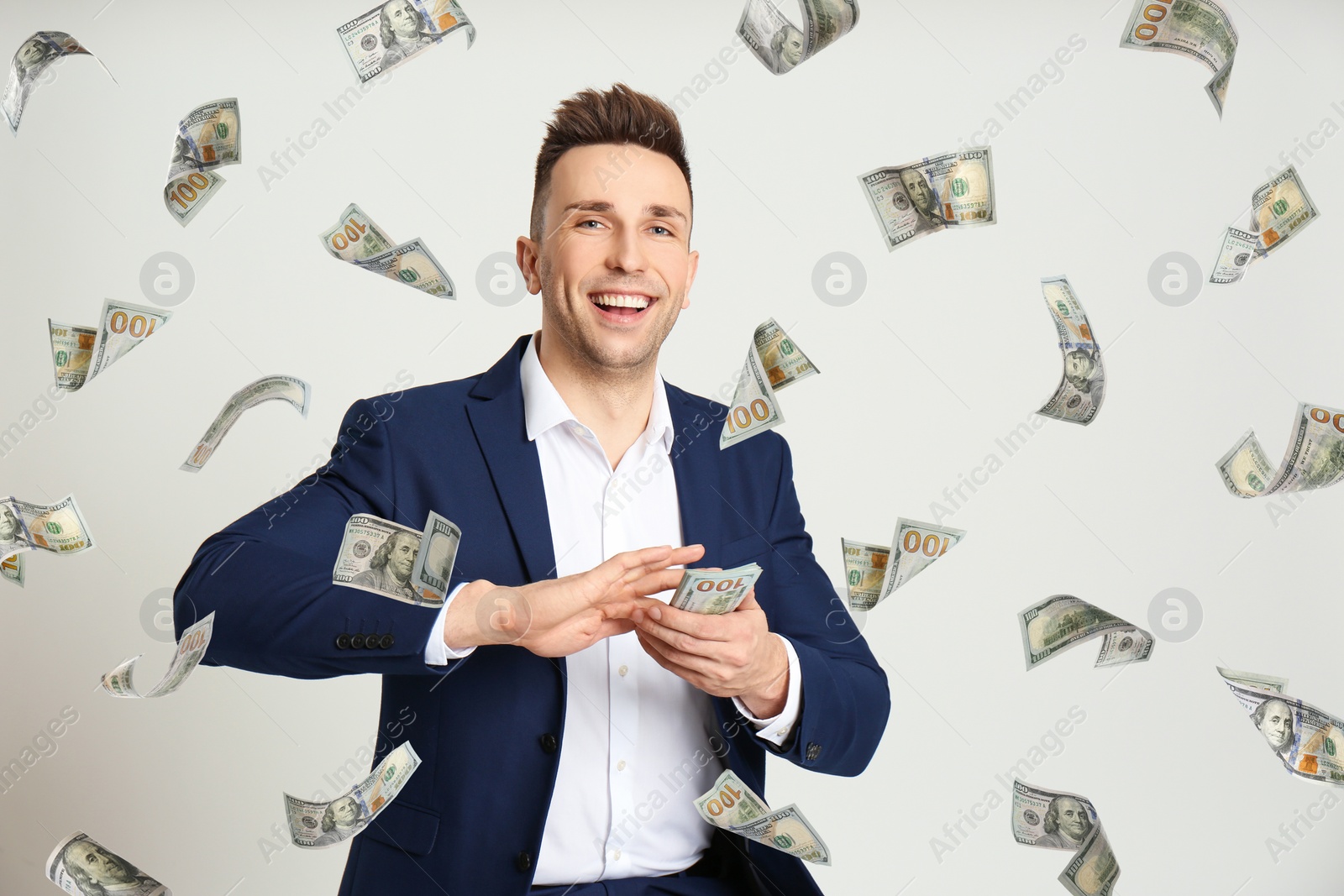 Image of Man throwing American dollars on light grey background