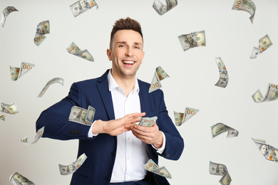 Man throwing American dollars on light grey background