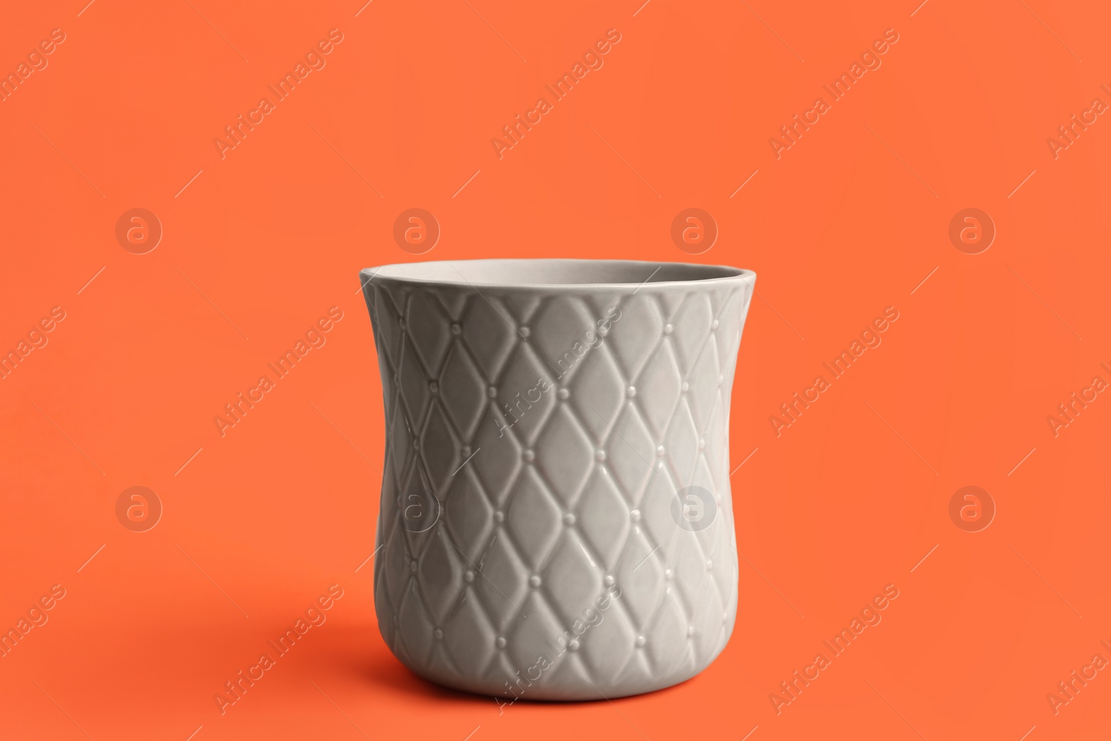 Photo of Stylish empty ceramic vase on orange background