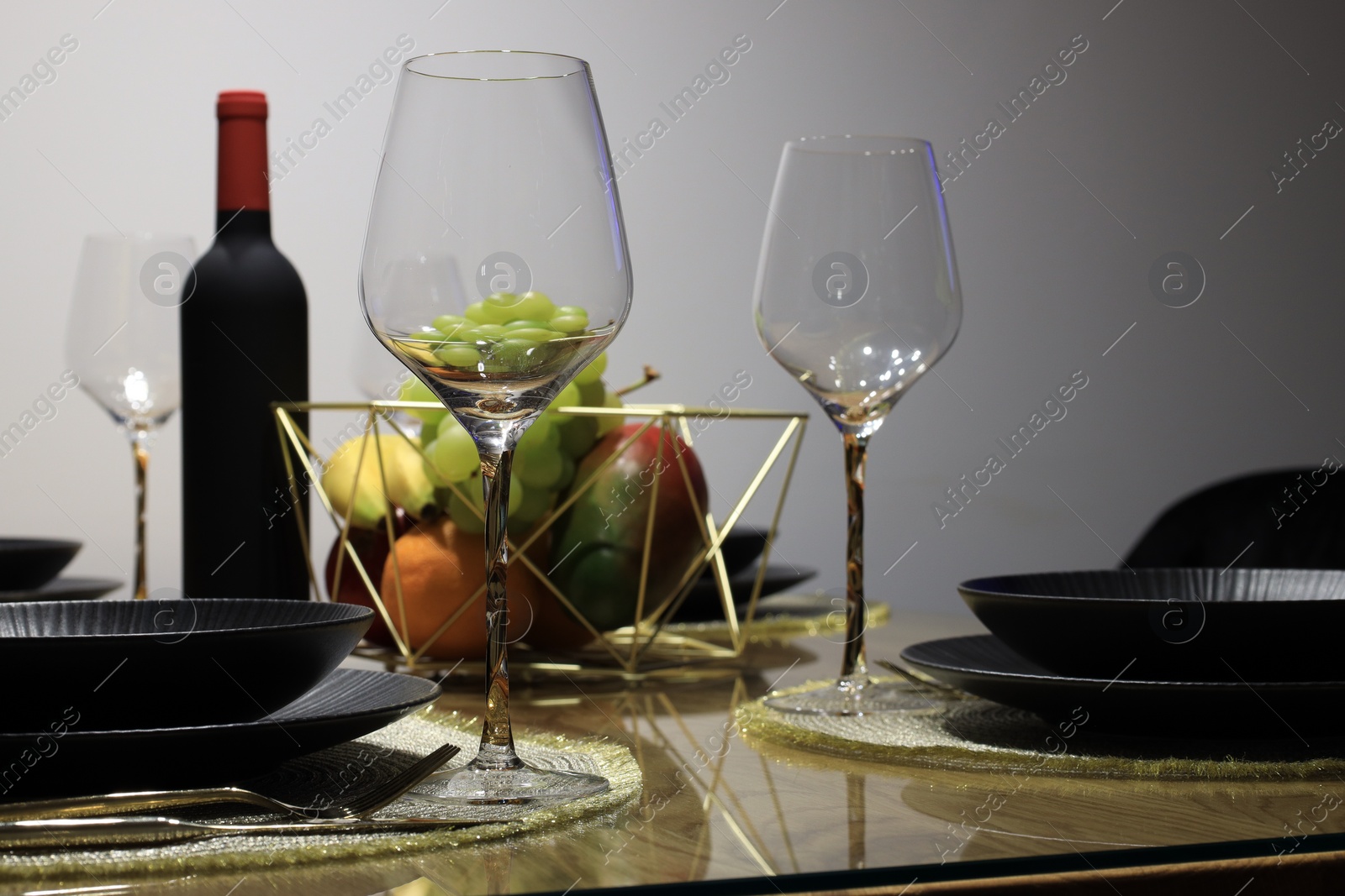 Photo of Bottle of wine, plates, fresh fruits and glasses on table