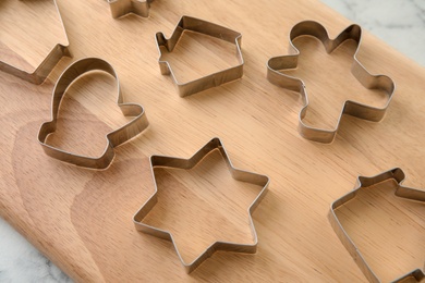 Cutters for homemade Christmas cookies on wooden board