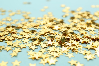 Photo of Confetti stars on light blue background, closeup. Christmas celebration