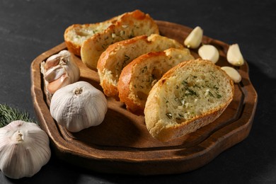 Tasty baguette with garlic and dill on grey table