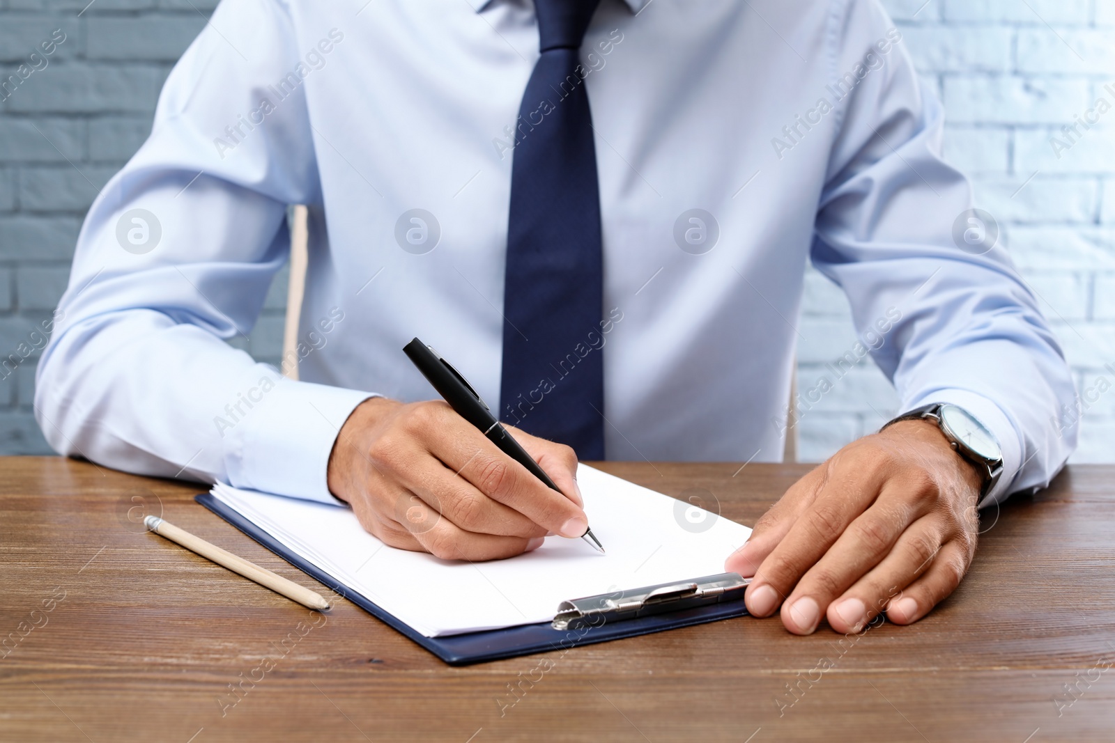 Photo of Male lawyer working with documents at table, closeup. Notary services