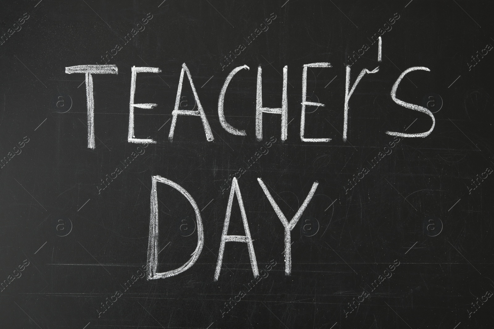 Photo of Words TEACHER'S DAY written with chalk on blackboard