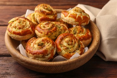 Photo of Fresh delicious puff pastry with tasty filling on wooden table, closeup