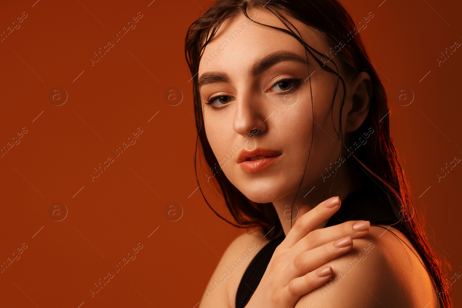 Photo of Portrait of beautiful woman on brown background. Space for text