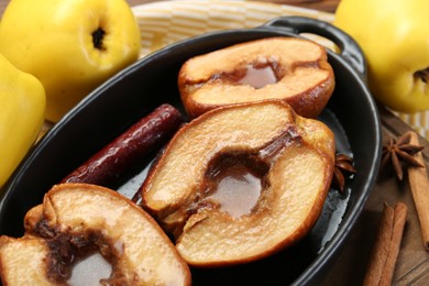 Photo of Tasty baked quinces with spices and honey in dish on table, closeup