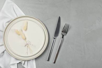 Photo of Stylish setting with elegant cutlery on grey table, top view. Space for text