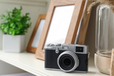 Photo of White shelving unit with retro camera and photo frames