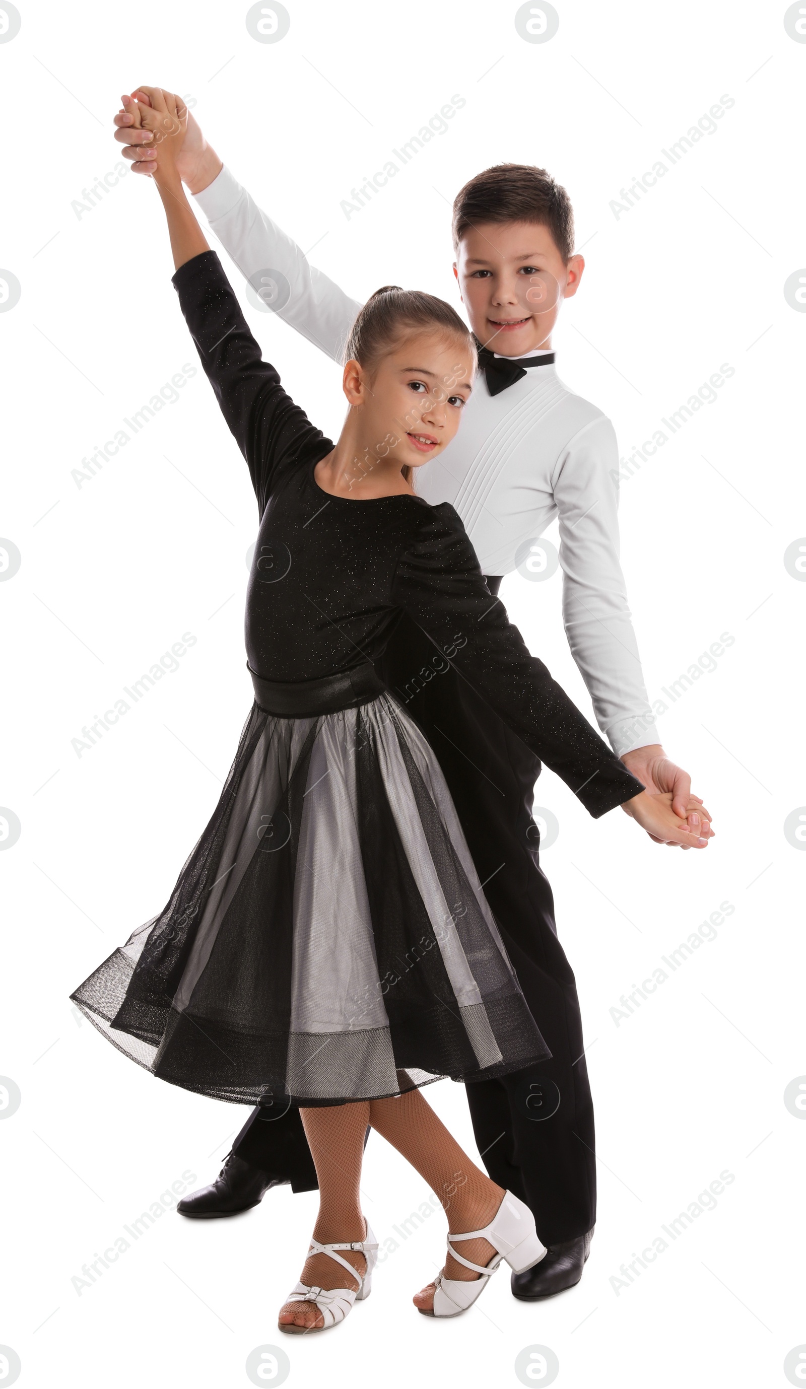 Photo of Beautifully dressed couple of kids dancing on white background