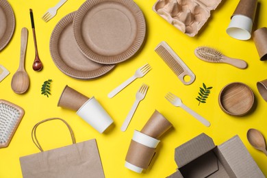 Photo of Different eco items on yellow background, flat lay. Recycling concept
