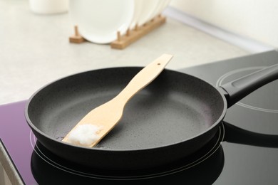 Photo of Frying pan with coconut oil on induction stove, closeup. Healthy cooking