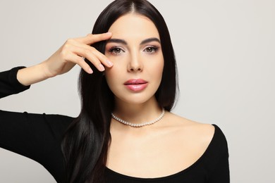 Portrait of beautiful young woman on light grey background