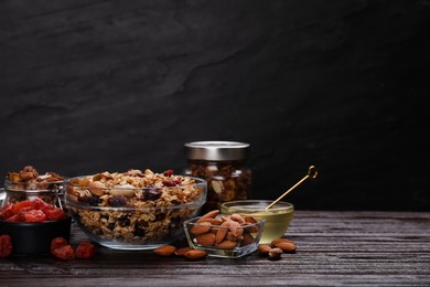 Tasty granola with nuts and dry fruits on wooden table. Space for text