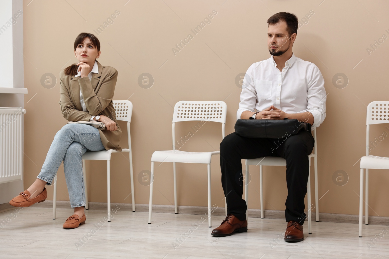 Photo of Man and woman waiting for job interview indoors