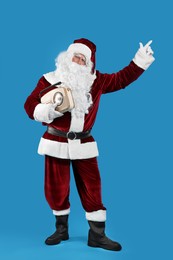 Santa Claus with vintage radio on blue background. Christmas music