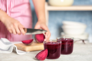 Glasses of beet smoothies and blurred woman on background