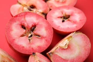 Photo of Tasty cut apples with red pulp on color background, closeup