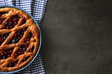 Delicious currant pie and fresh berries on grey table, top view. Space for text